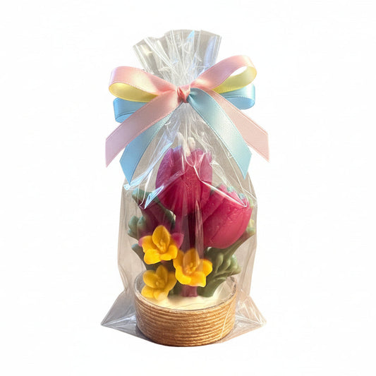 Decorative candle with pink tulip and yellow flower design on a white background