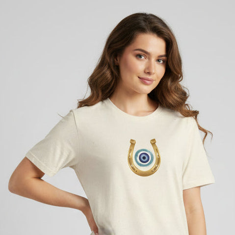 Beige t-shirt with a horseshoe and eye design on a white background