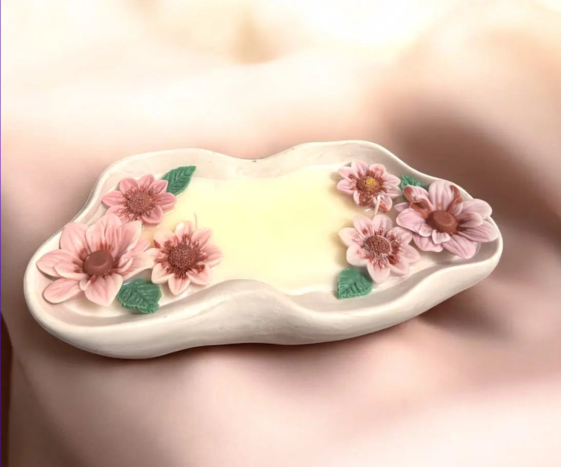 Handmade flower candle in unique container featuring pink and purple floral details on a soft background.