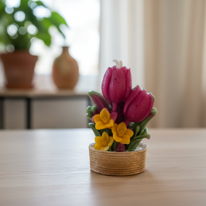 Decorative candle with pink tulip and yellow flower design on a white background